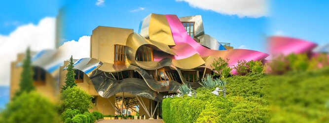 Trip Reisen Reisetipps - Marqués de Riscal Design Hotel, Bilbao, Elciego, Spanien. Fantastisch galaktisch, unverkennbar ein Werk von Frank O. Gehry. Inmitten idyllischer Weinberge in der Rioja Region des Baskenlandes, bezaubert das schimmernde Bauobjekt mit einer Struktur bunter, edel glänzender verflochtener Metallbänder. Glanz im Baskenland - Es muss etwas ganz Besonderes sein. Emotional, zukunftsweisend, einzigartig. Denn in dieser Region, etwa 133 km südlich von Bilbao, sind Weingüter normalerweise nicht für die Öffentlichkeit zugänglich.